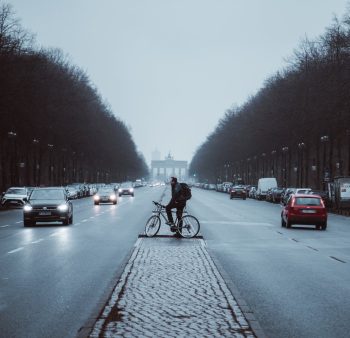 male cyclist waiting for passing cars during a foggy autumn day
