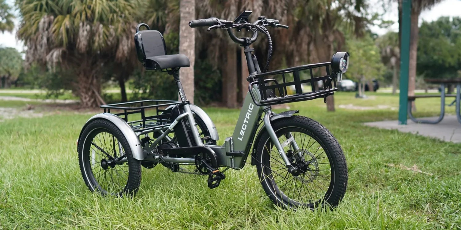 Lectric XP e-Trike sitting in grass next to picnic area and surrounded by trees - within post for GoTrax Everest Electric Dirt Bike 