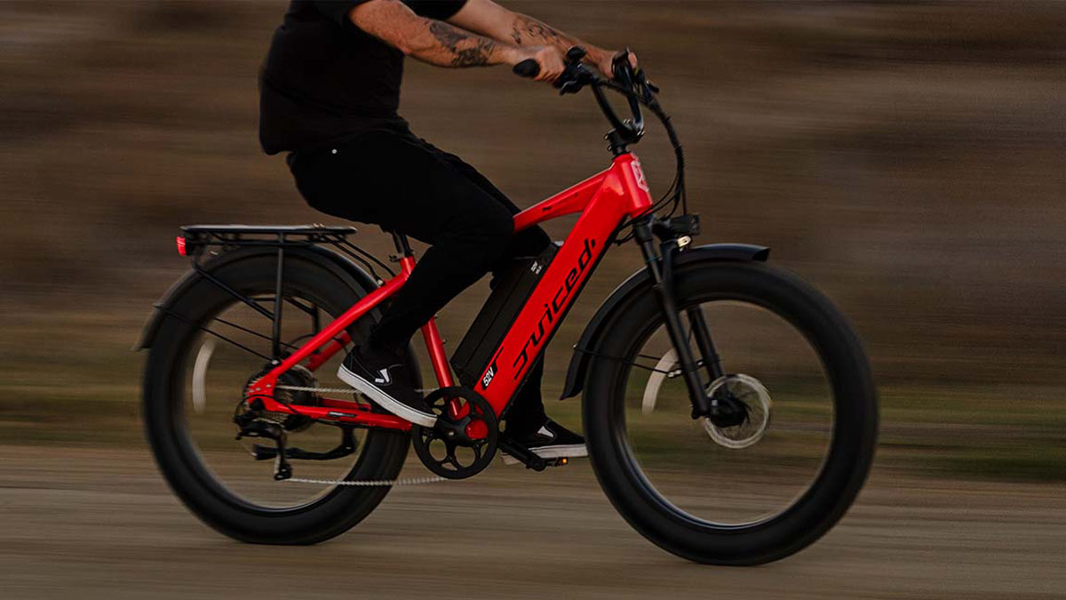 Juiced RipCurrent S Fat-Tire e-bike being ridden by man in all black, within post for Jackery Explorer 2000 Pro bundle