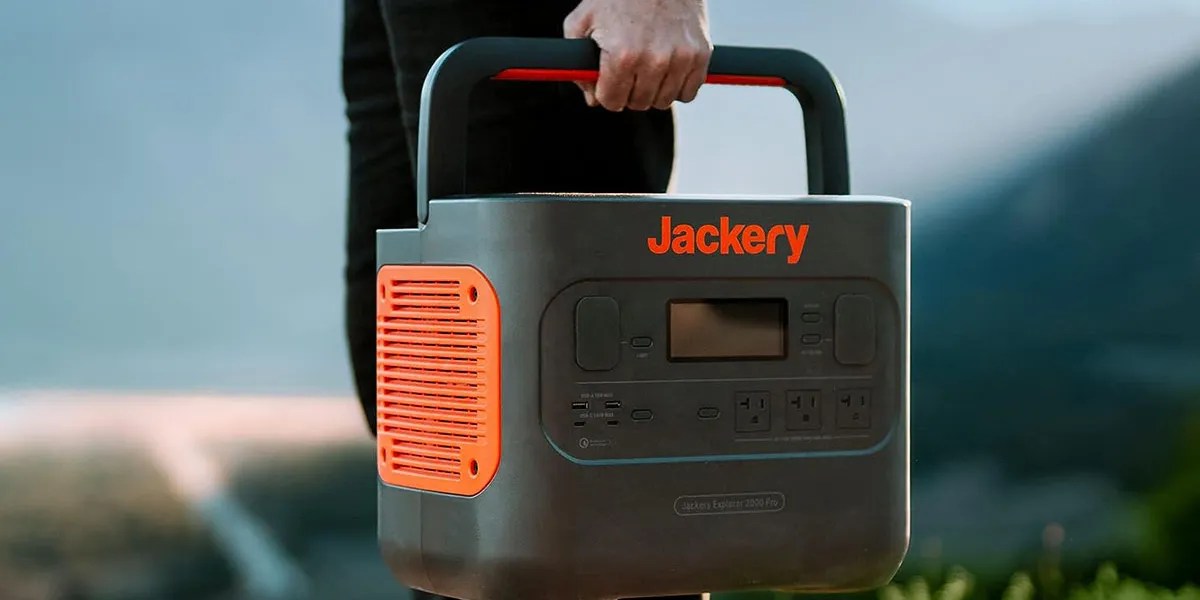 Jackery 2000 Pro portable power station being held by handle within post for NIU electric scooter