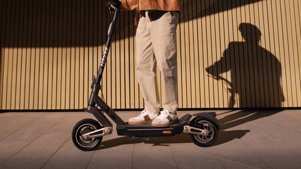 man riding Navee ST3 Pro electric scooter down walkway