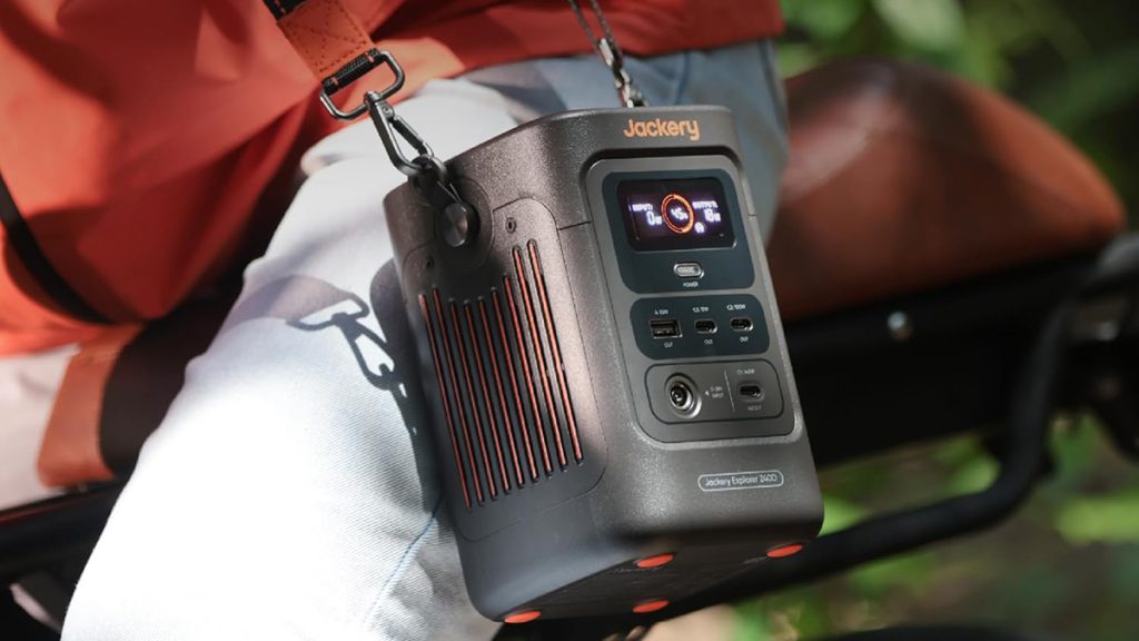 person riding bike with Jackery's Explorer 240D power station hanging from shoulder on strap