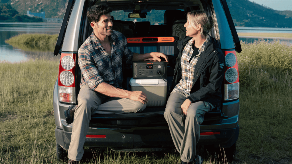man and woman sitting in car trunk with Jackery Explorer 600 v2 power station