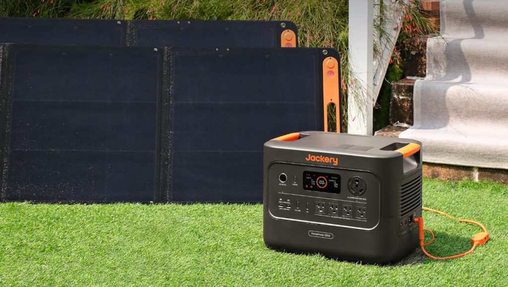 jackery's explorer 3000 v2 (homepower 3000) power station in yard with two solar panels