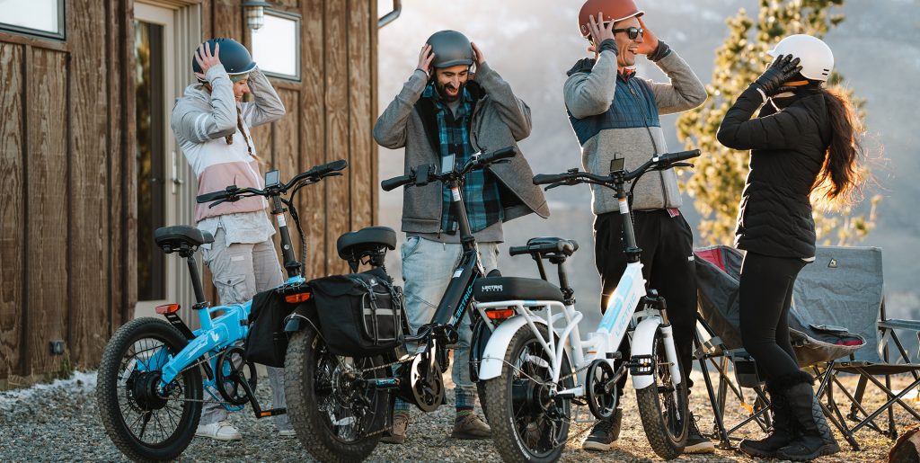 four people putting on helmets to ride Lectric XP4 e-bikes in winter