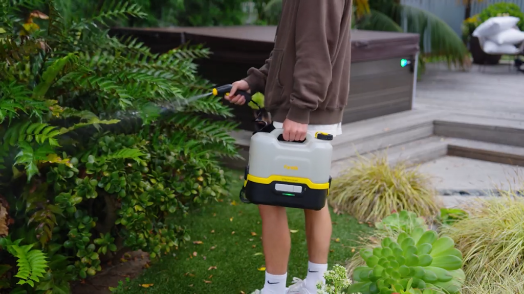 man watering garden with Fanttik cordless electric pressure washer