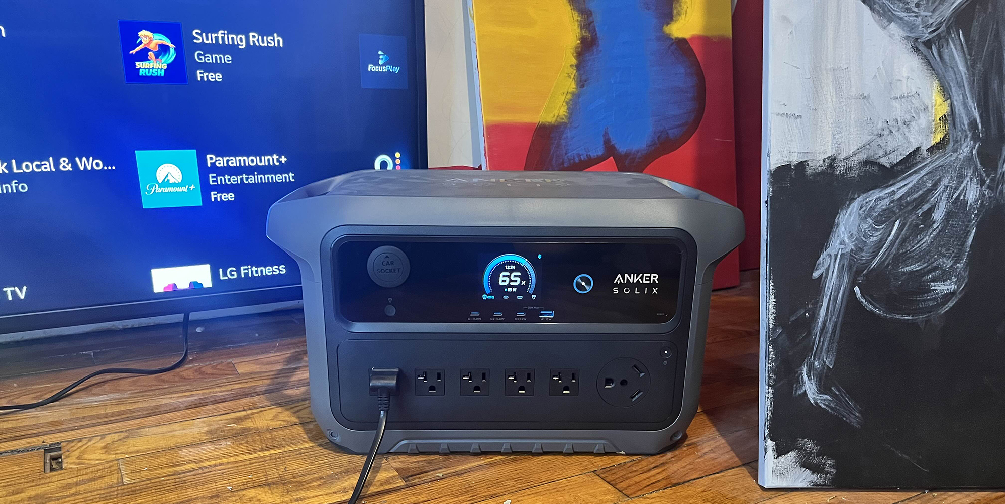 Anker SOLIX C2000 Gen 2 power station in front of TV and surrounded by art