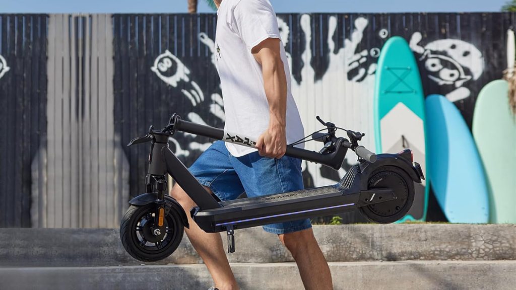 man carrying Gotrax Eclipse electric scooter