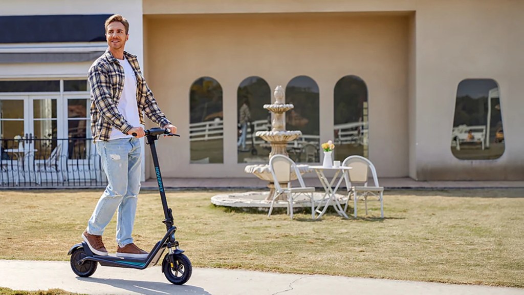 man riding Hoverfly X5 e-scooter down sidewalk