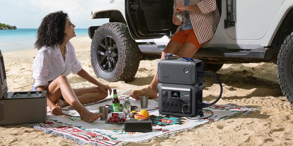 woman using Anker SOLIX C1000 and BP1000 expansion battery at beach