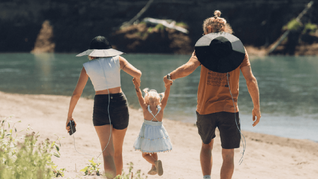 parents and child walking on beach with EcoFlow solar power hats