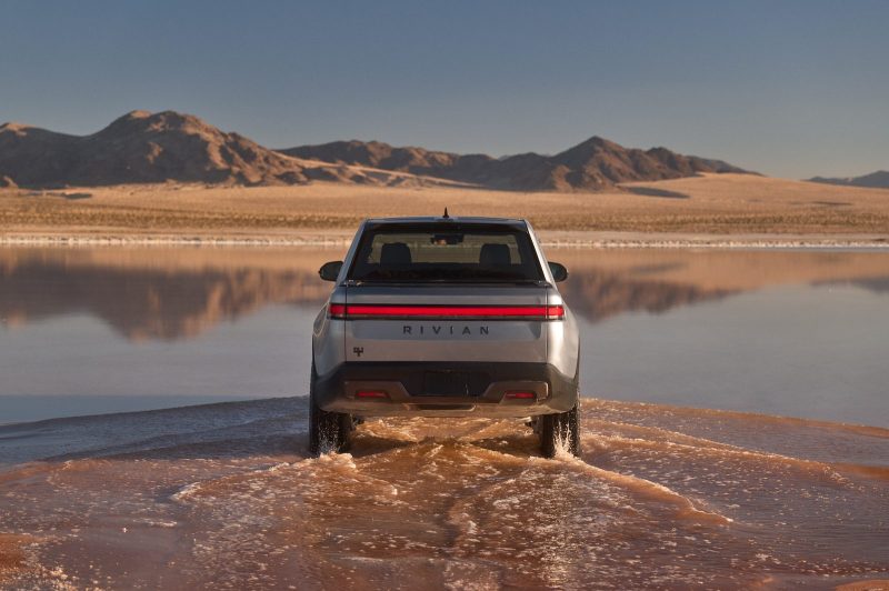 Rear of the 2027 Rivian R1T in Esker Silver crossing water