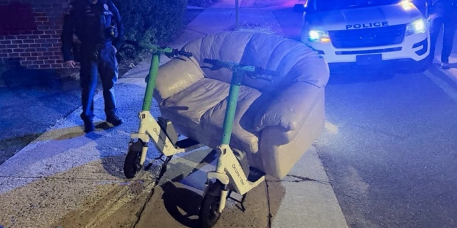 Police pull over two men riding an electric couch down the street
