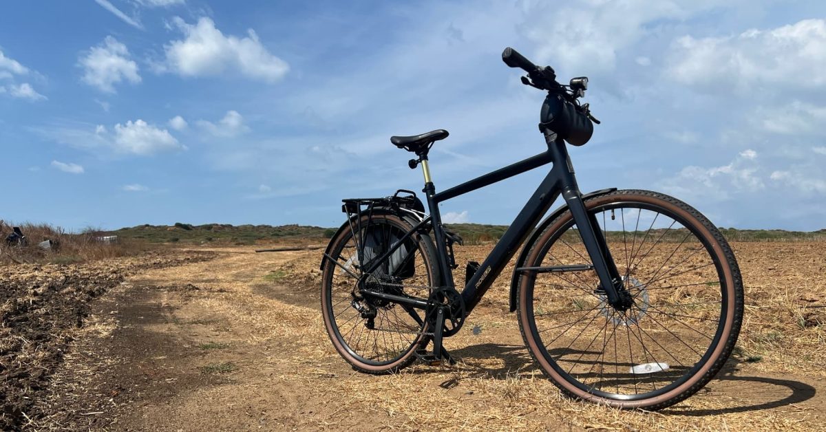A lightweight Ride1Up Roadster V3 electric bike parked on a gravel trail after an off-road ride